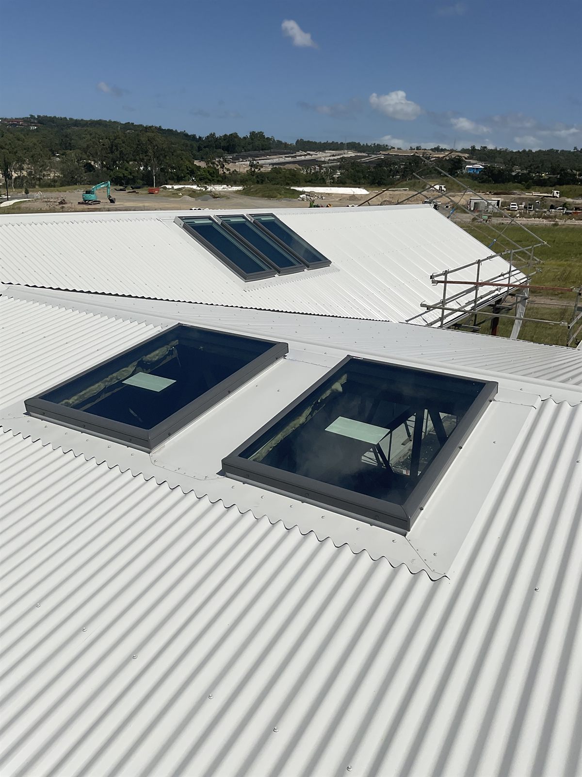 A Velux skylight flashed into a white Colorbond roof under coastal sun