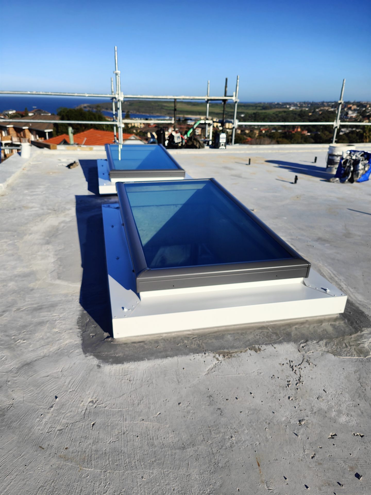 A modern Velux skylight installed on a flat roof, replacing an older unit