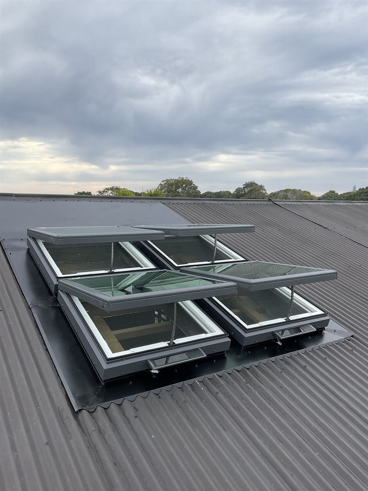 A bank of Velux solar opening skylights venting on a Colorbond roof