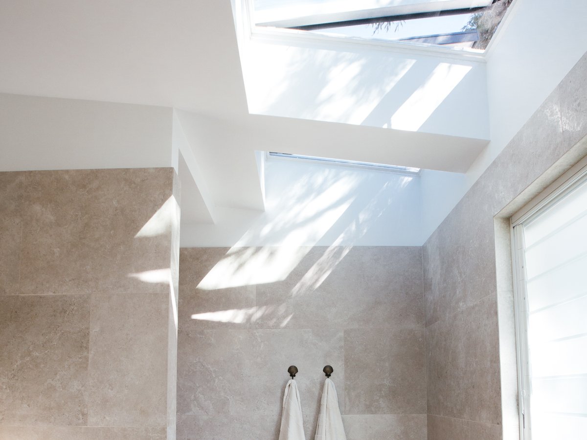 An openable Velux skylight venting fresh air into a bright bathroom