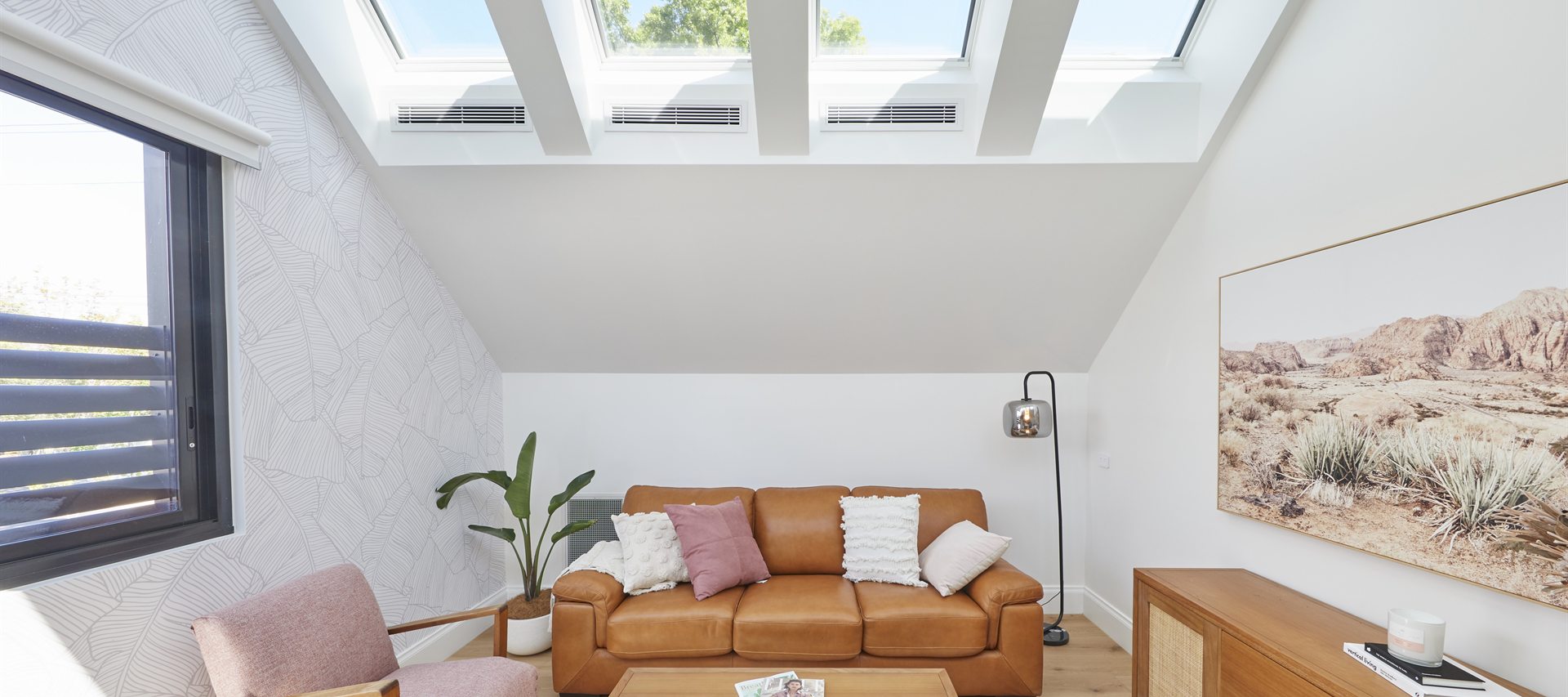 Velux skylights set into a raked ceiling, filling a living room with natural light